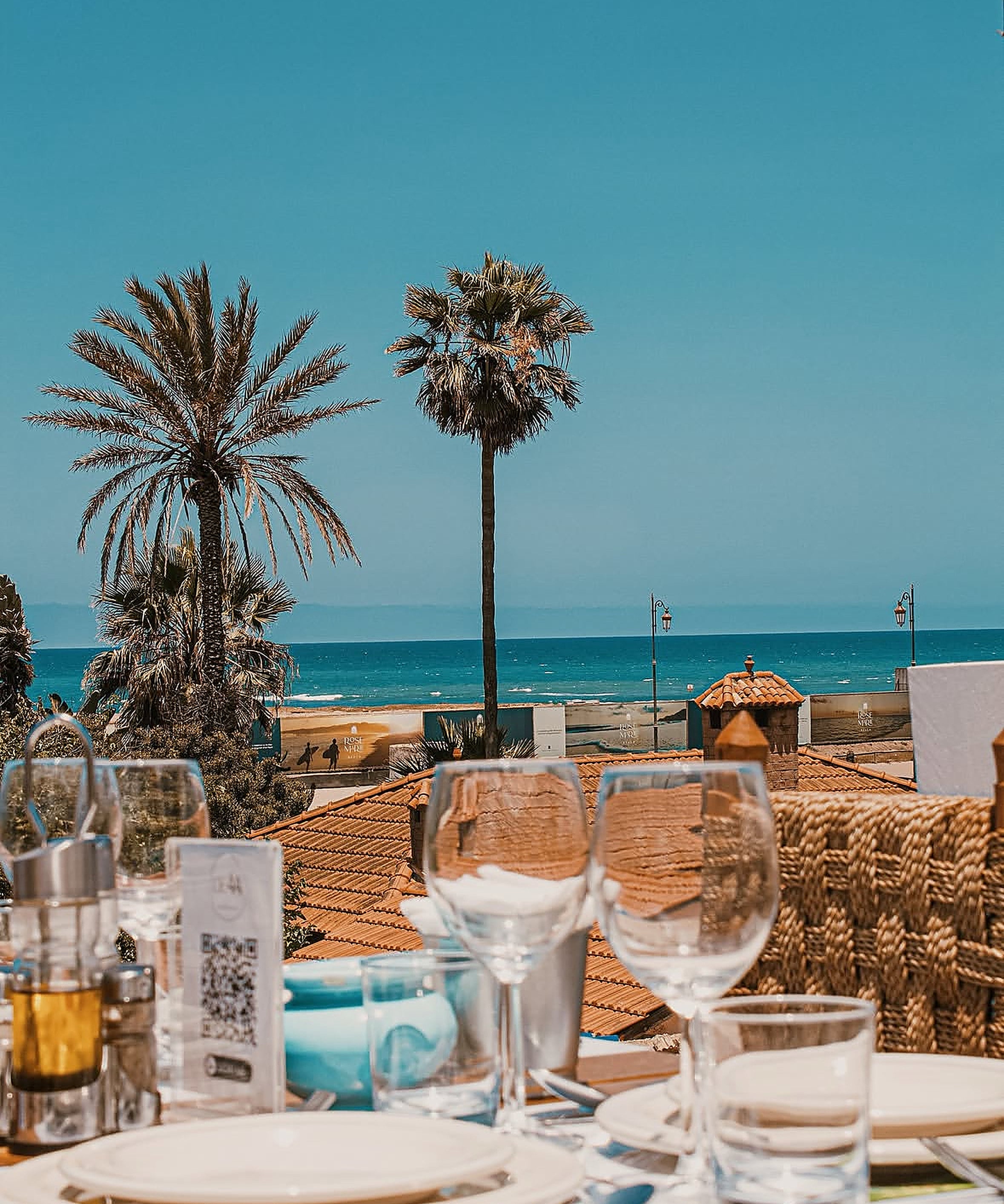 Shooting éditorial Le 44 Rooftop : vue terrasse sur la mer, palmiers et table dressée à Skhirat
